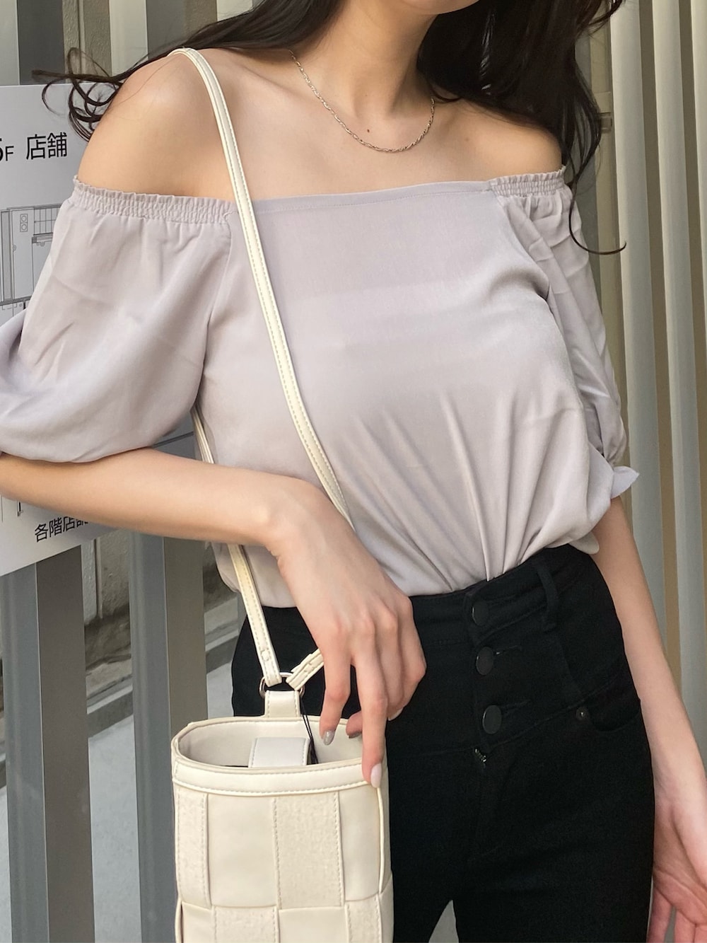 ホワイト系のショルダーバッグ、ブラック系のサンダル、ブラック系のデニムパンツを着用したレディースの春コーディネートの3枚目の写真