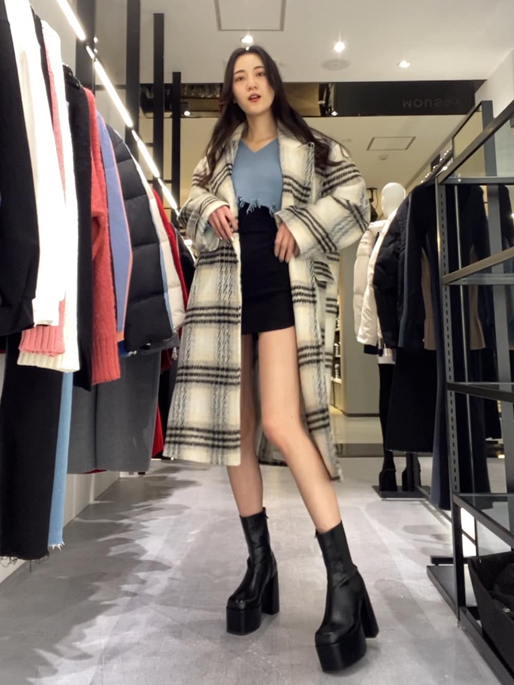 ブラック系のスカート、ブルー系のニット/セーター、その他のチェスターコートを着用したレディースの冬コーディネートの2枚目の写真