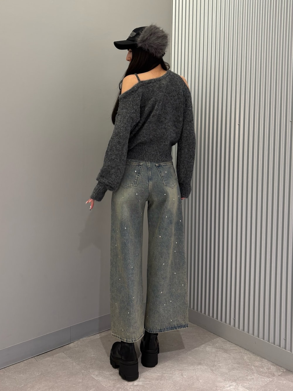 ブルー系のデニムパンツ、グレー系のニット/セーター、ブラック系のブーツを着用したレディースの冬コーディネートの3枚目の写真