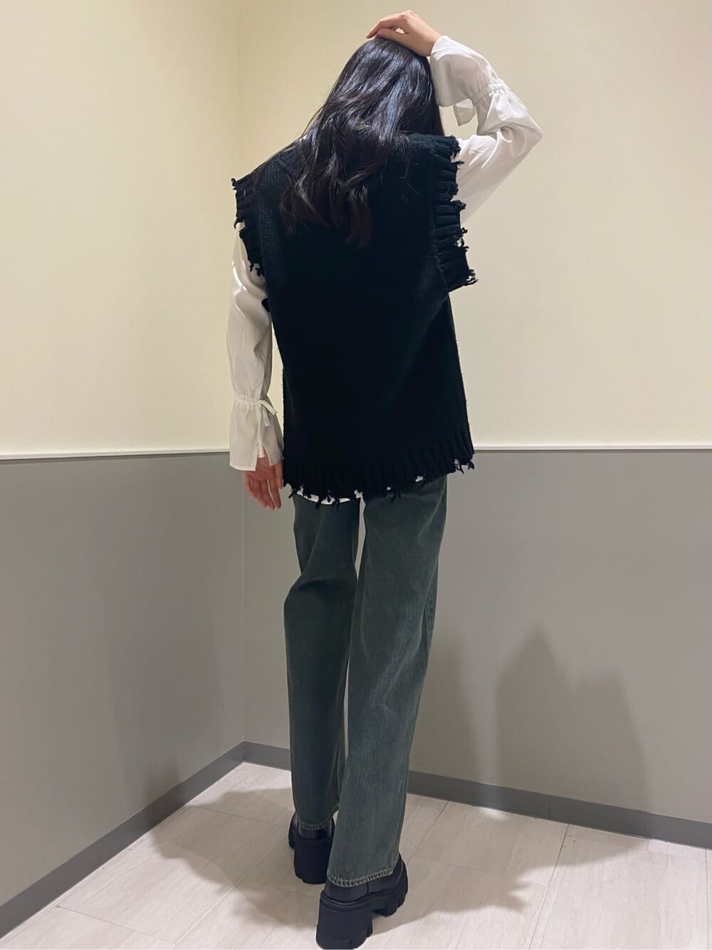 ブラック系のブーツ、ホワイト系のシャツ/ブラウス、ブルー系のデニムパンツを着用したレディースの秋コーディネートの3枚目の写真