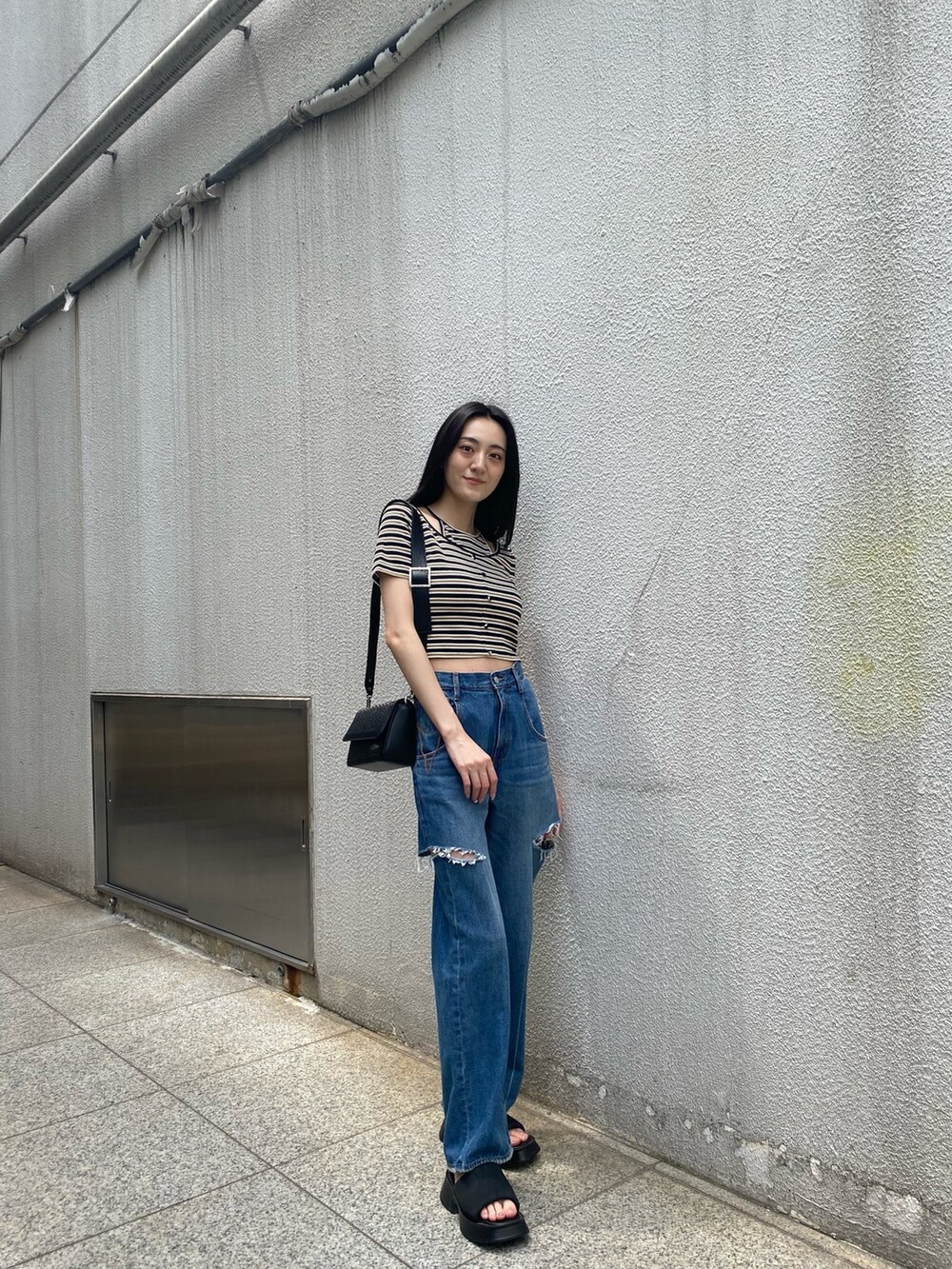 その他のTシャツ/カットソー、ブラック系のサンダル、ブルー系のデニムパンツを着用したレディースの夏コーディネートの2枚目の写真