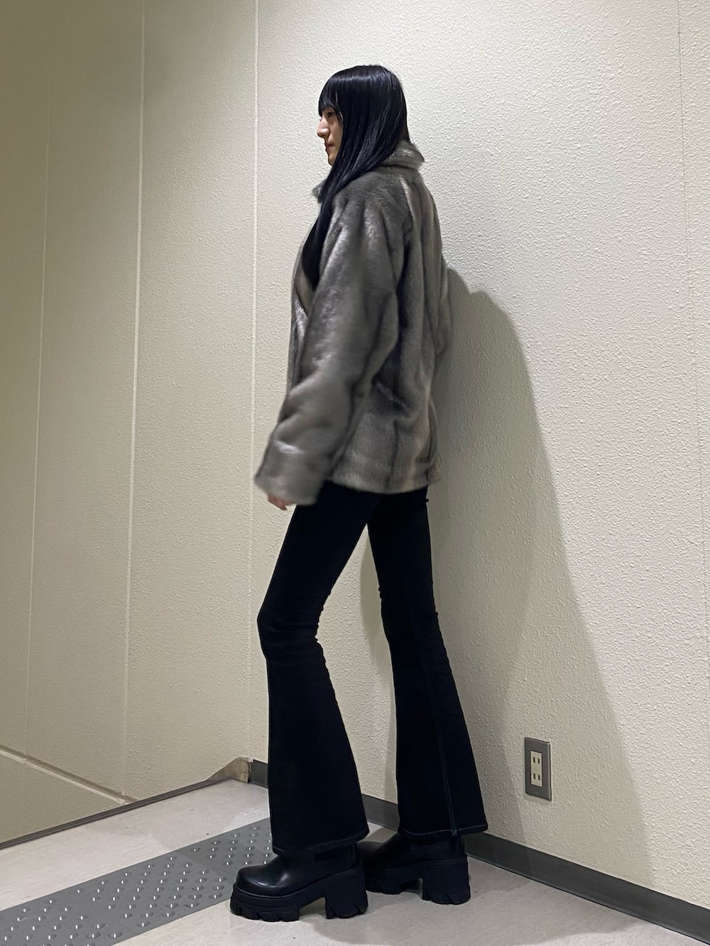 ブラック系のデニムパンツ、ブラック系のブーツ、ブラック系のニット/セーターを着用したレディースの冬コーディネートの4枚目の写真