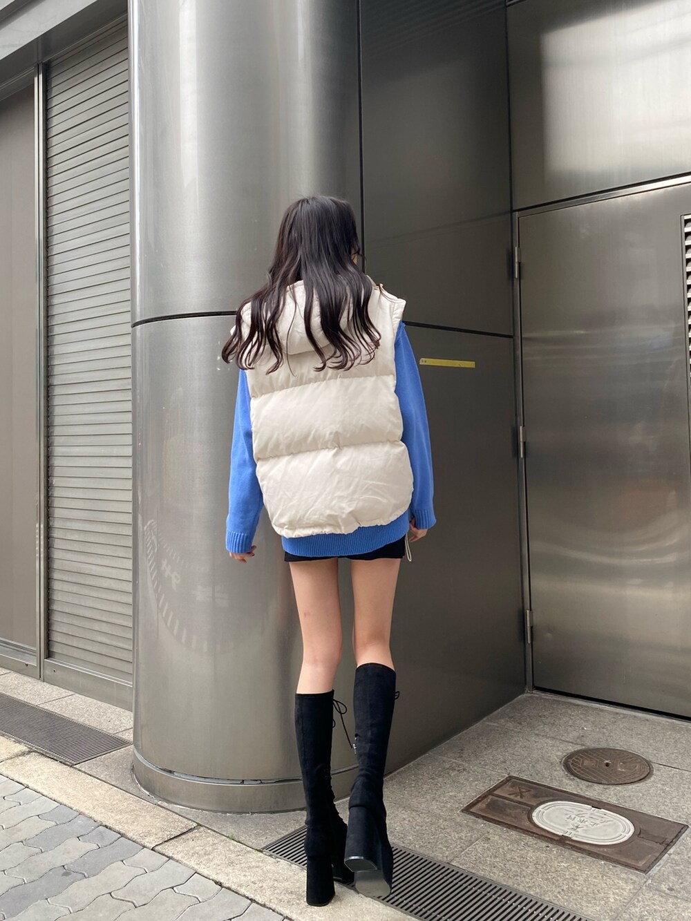 ブルー系のニット/セーター、ホワイト系のダウンジャケット/コート、ブラック系のスカートを着用したレディースの冬コーディネートの4枚目の写真