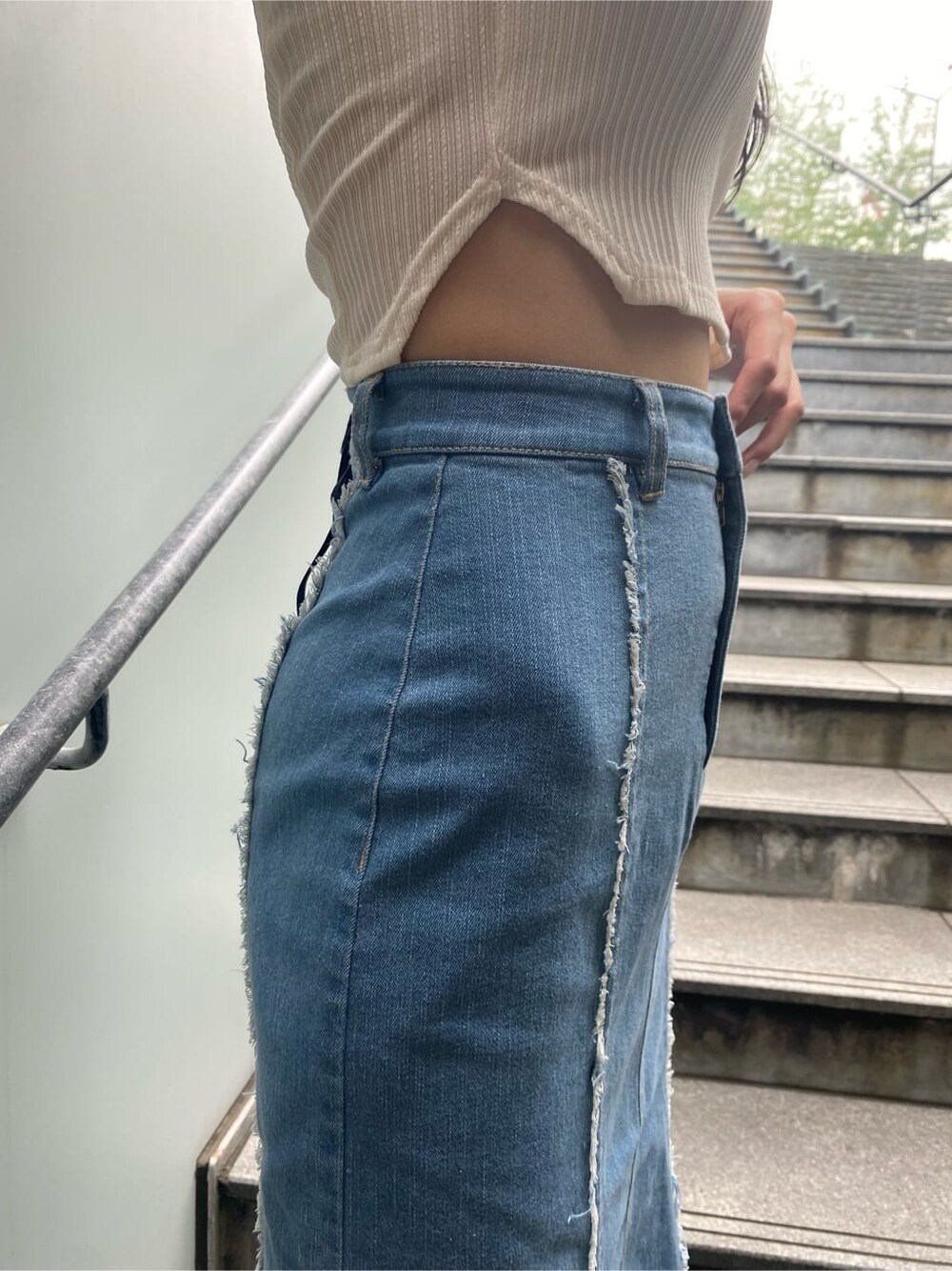 ブルー系のスカート、ホワイト系のタンクトップ、ブラック系のサンダルを着用したレディースの夏コーディネートの7枚目の写真