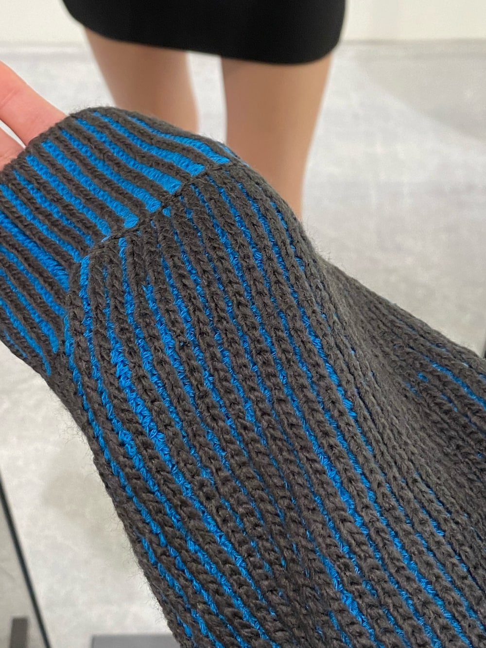 ブラック系のスカート、ブラック系のブーツ、ブルー系のニット/セーターを着用したレディースの秋コーディネートの9枚目の写真