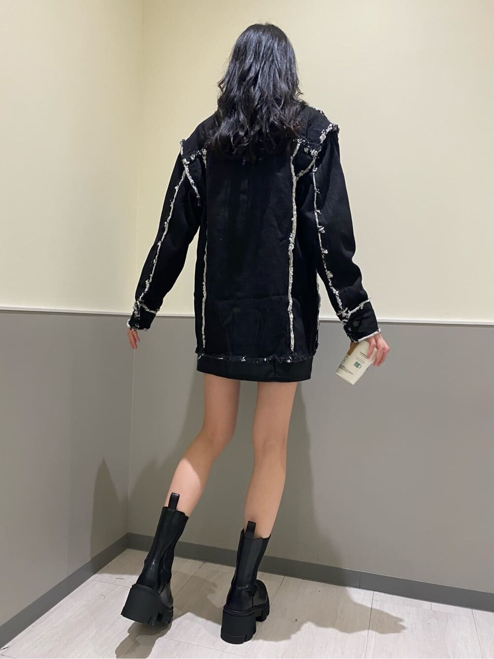 ブラック系のブーツ、ブラック系のデニムジャケット、ホワイト系のスウェットを着用したレディースの秋コーディネートの4枚目の写真