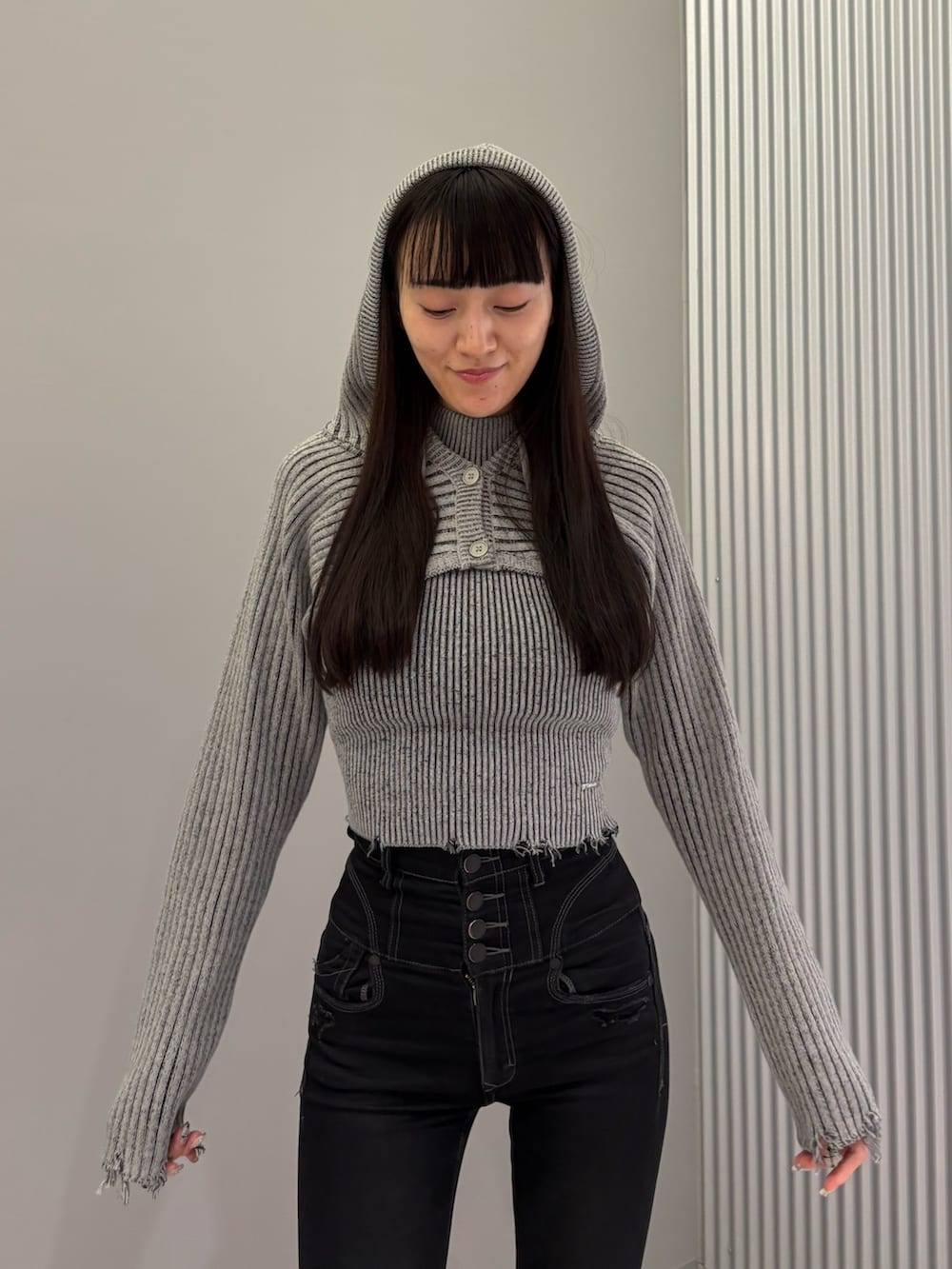 ブラック系のデニムパンツ、ブラック系のブーツ、グレー系のニット/セーターを着用したレディースの秋コーディネートの7枚目の写真