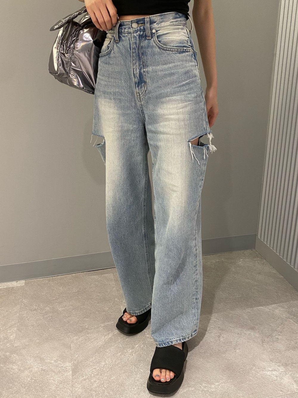 ブラック系のTシャツ/カットソー、ブラック系のサンダル、ブルー系のデニムパンツを着用したレディースの夏コーディネートの8枚目の写真