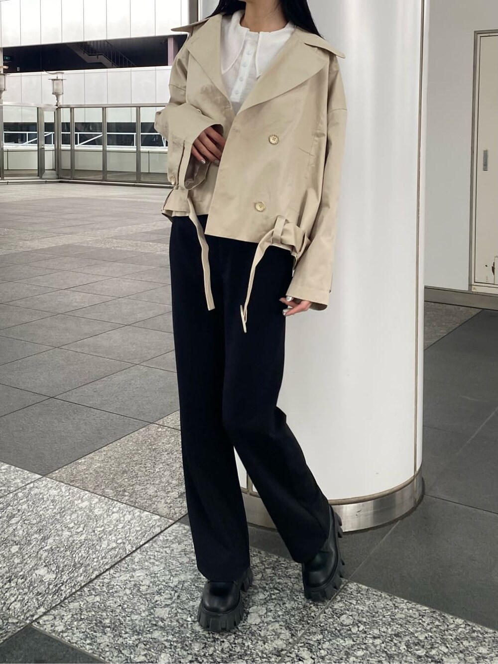 ブラック系のその他パンツ、ベージュ系のトレンチコート、ブラック系のブーツを着用したレディースの冬コーディネートの3枚目の写真