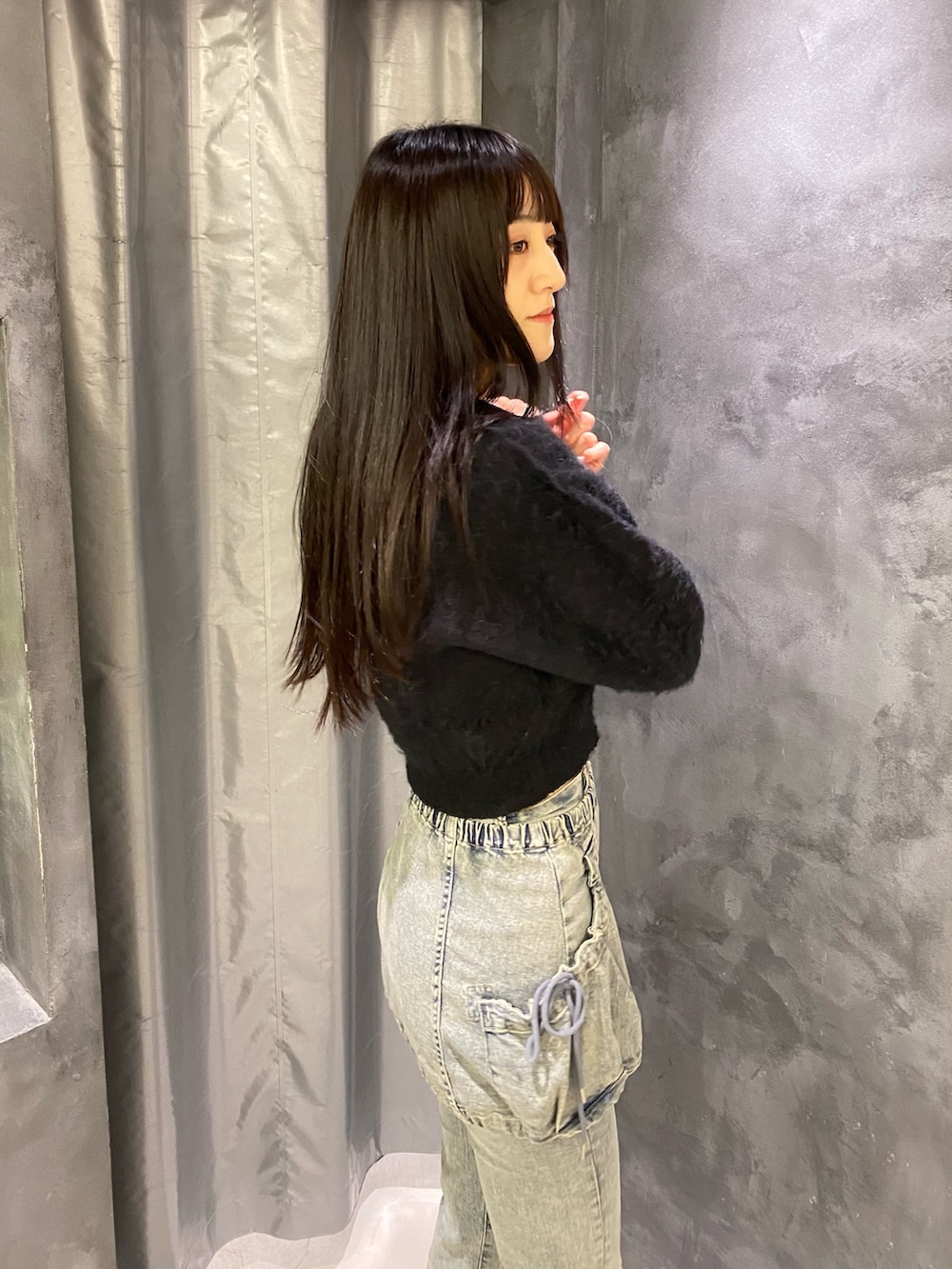 ブルー系のデニムパンツ、ブラック系のニット/セーター、ブラック系のブーツを着用したレディースの秋コーディネートの6枚目の写真