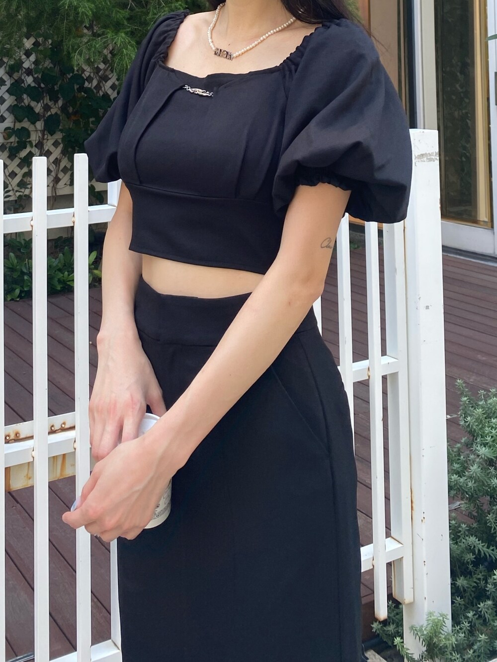 ブラック系のスカート、ブラック系のTシャツ/カットソー、シルバー系のネックレスを着用したレディースの夏コーディネートの8枚目の写真