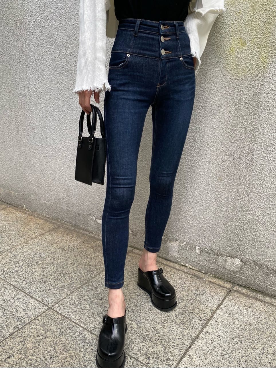 ブルー系のデニムパンツ、ブラック系のスリッポン、ブラック系のTシャツ/カットソーを着用したレディースの秋コーディネートの5枚目の写真