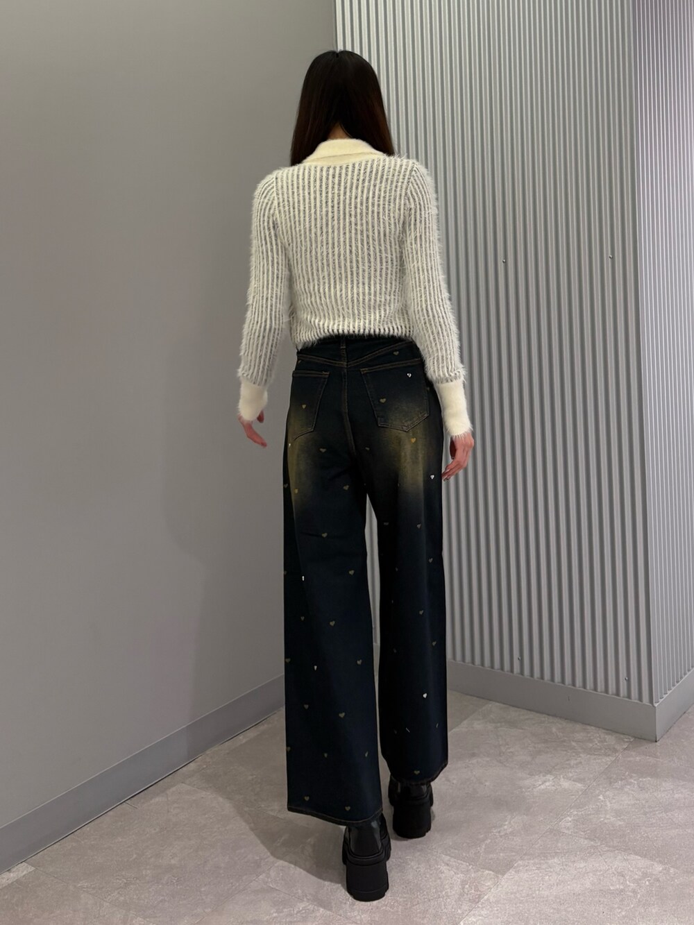 ブルー系のデニムパンツ、ホワイト系のニット/セーター、ブラック系のブーツを着用したレディースの秋コーディネートの4枚目の写真