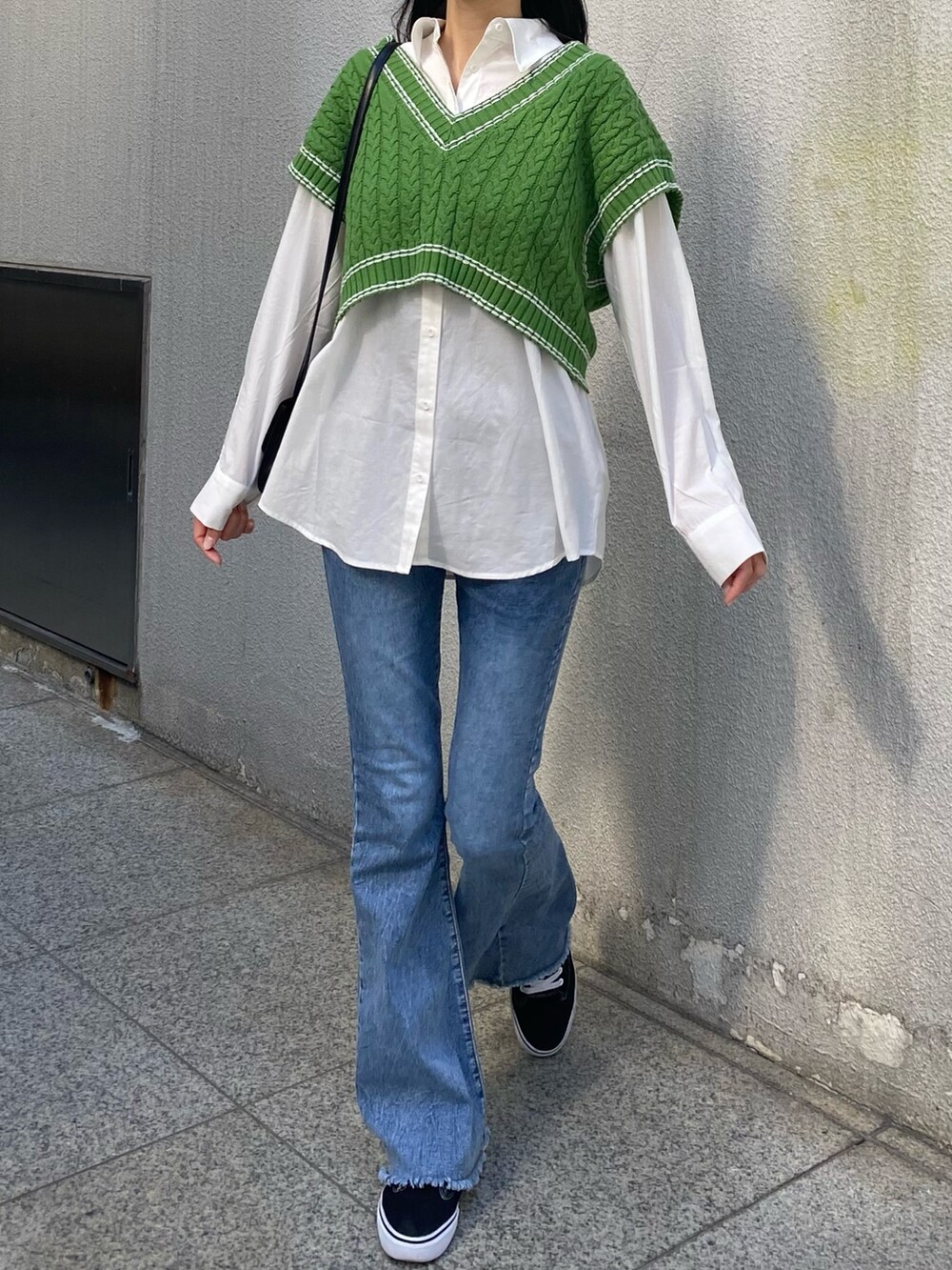 グリーン系のベスト、ホワイト系のシャツ/ブラウス、ブラック系のショルダーバッグを着用したレディースの冬コーディネートの5枚目の写真