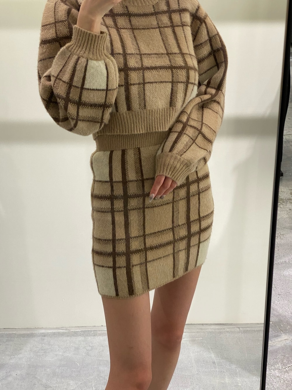 ベージュ系のニット/セーター、ベージュ系のスカート、ブラック系のブーツを着用したレディースの冬コーディネートの3枚目の写真