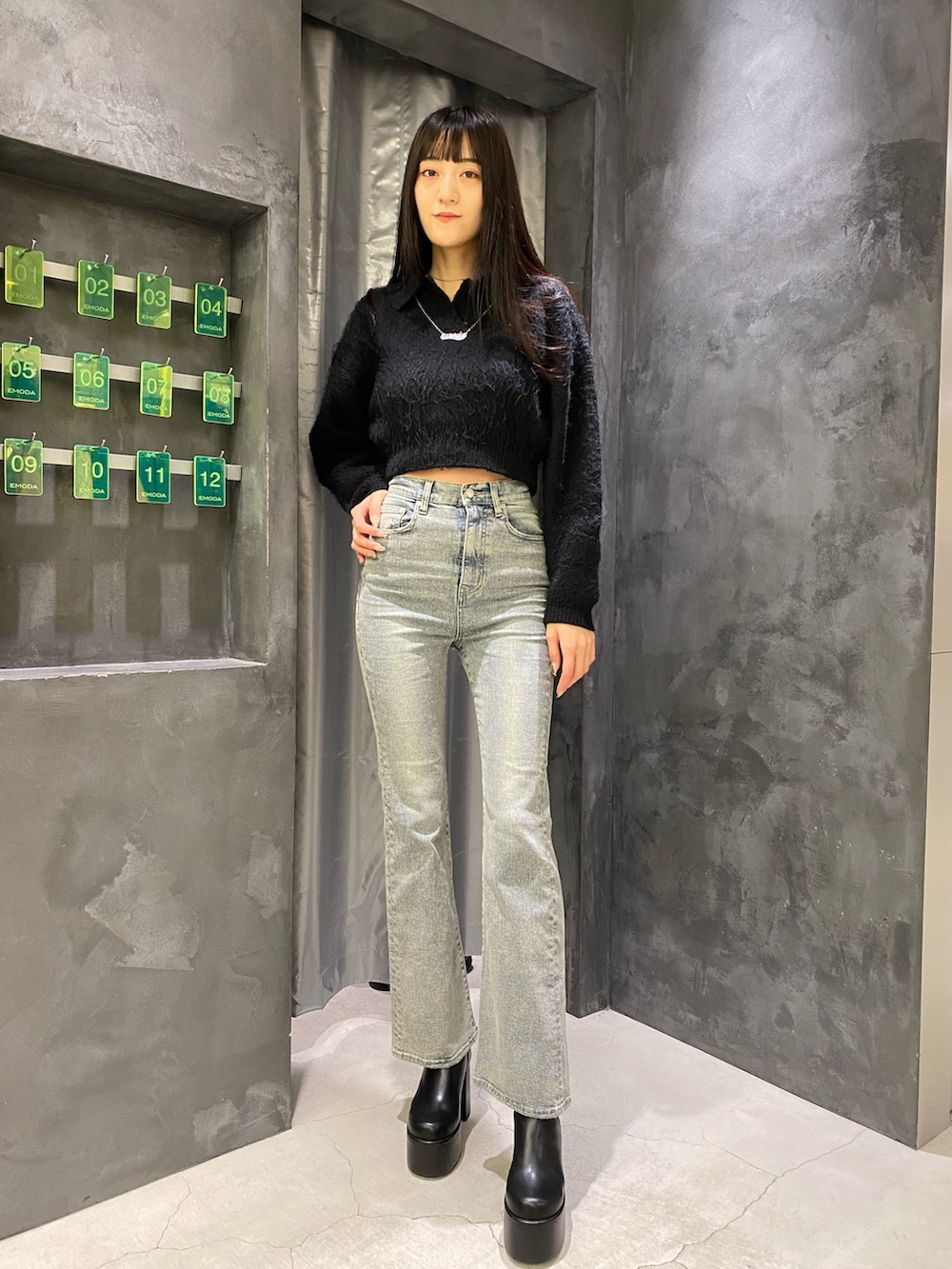 ブルー系のデニムパンツ、ブラック系のニット/セーター、ブラック系のブーツを着用したレディースの秋コーディネートの7枚目の写真