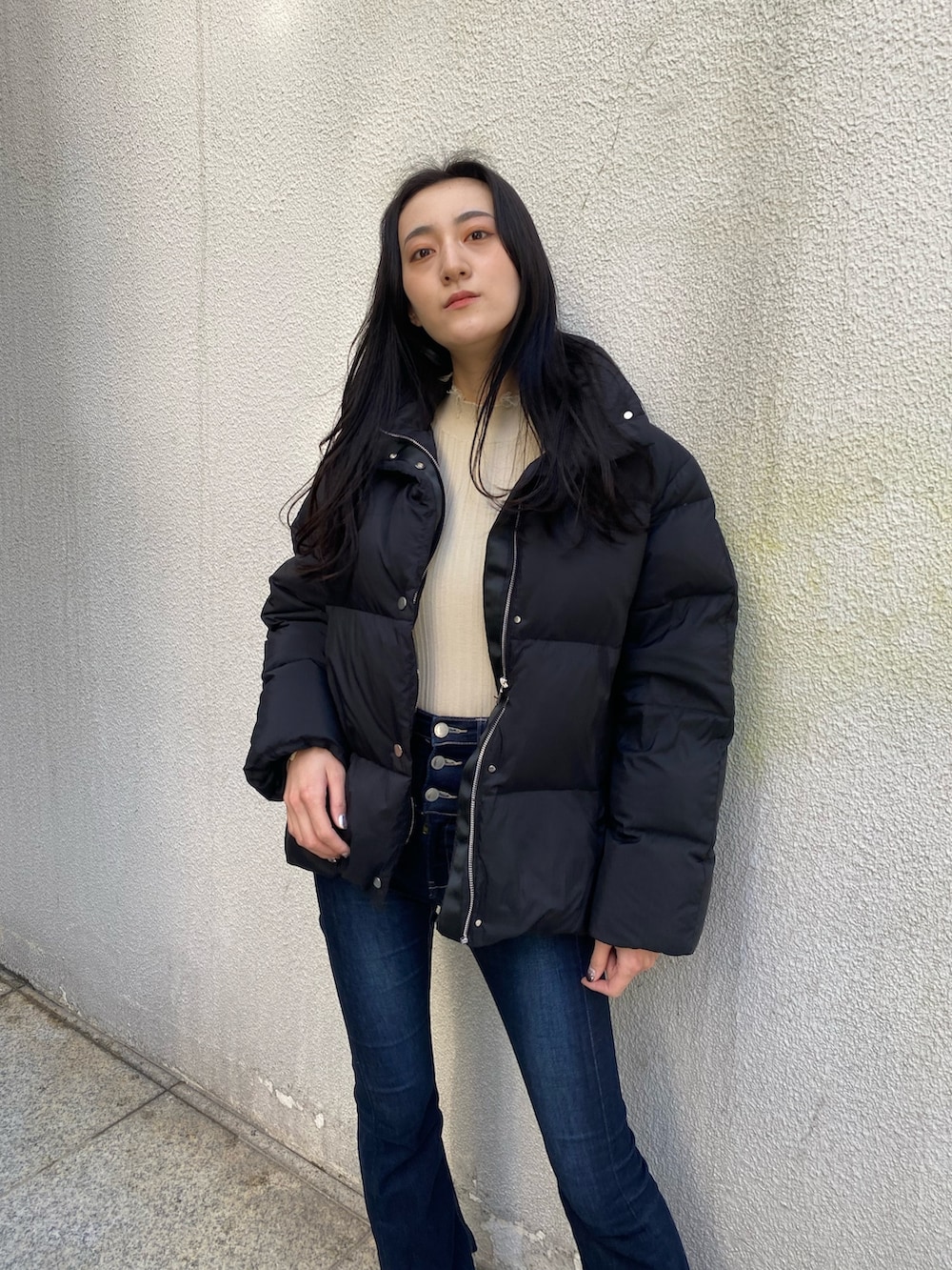 ブルー系のデニムパンツ、ホワイト系のニット/セーター、ブラック系のブーツを着用したレディースの冬コーディネートの5枚目の写真