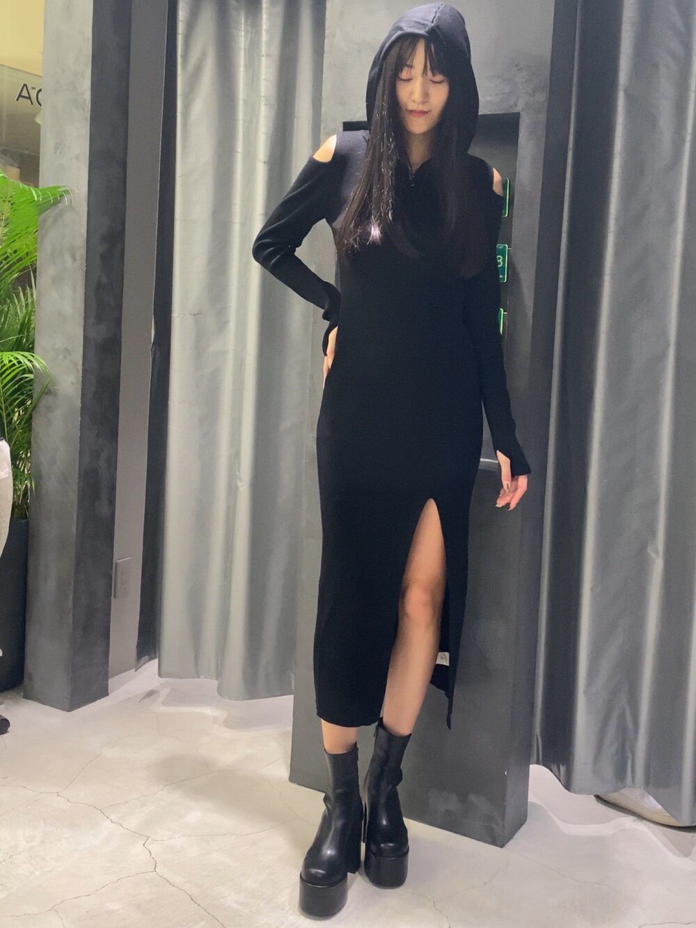 ブラック系のワンピース、ブラック系のブーツを着用したレディースの秋コーディネートの2枚目の写真