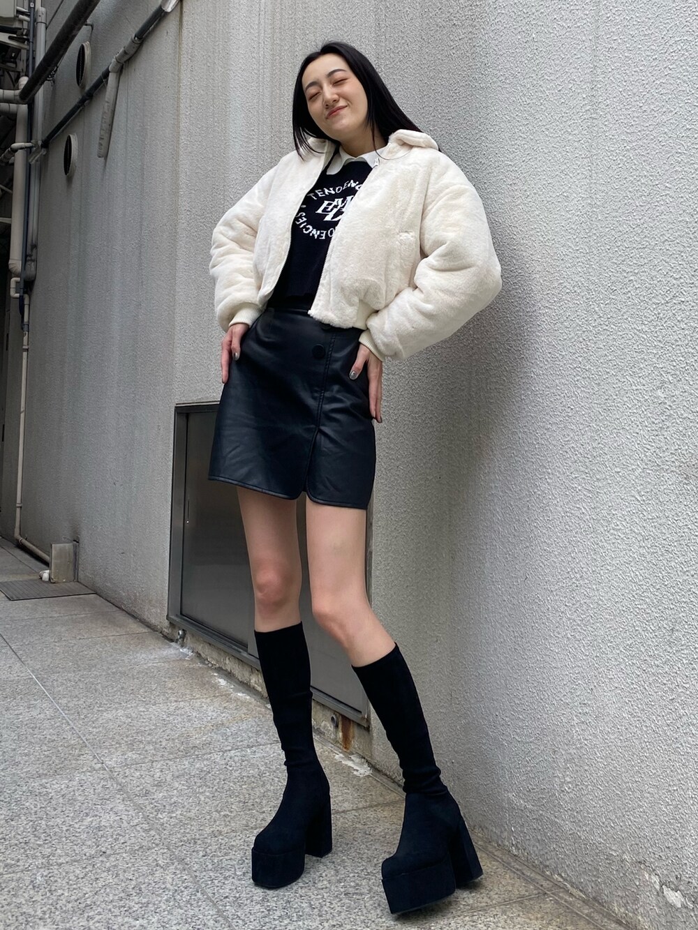 ブラック系のニット/セーター、ホワイト系のブルゾン、その他のスカートを着用したレディースの秋コーディネートの3枚目の写真