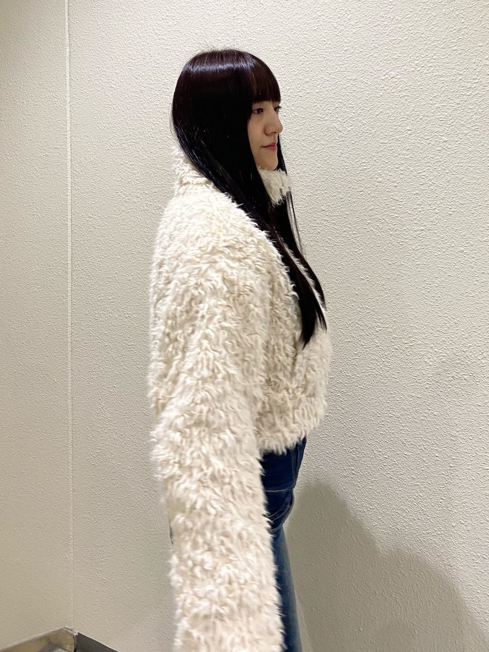 ブルー系のデニムパンツ、ホワイト系のブルゾンを着用したレディースの秋コーディネートの4枚目の写真