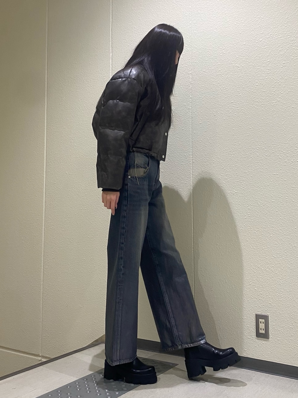 ブルー系のデニムパンツ、ブラウン系のダウンジャケット/コート、ブラック系のブーツを着用したレディースの冬コーディネートの4枚目の写真