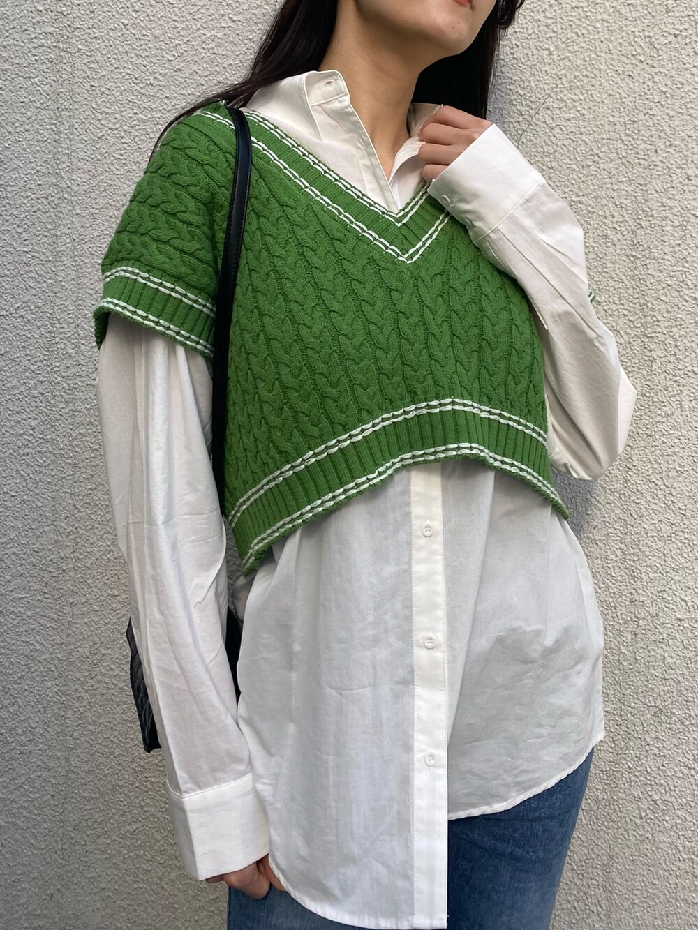 グリーン系のベスト、ホワイト系のシャツ/ブラウス、ブラック系のショルダーバッグを着用したレディースの冬コーディネートの7枚目の写真