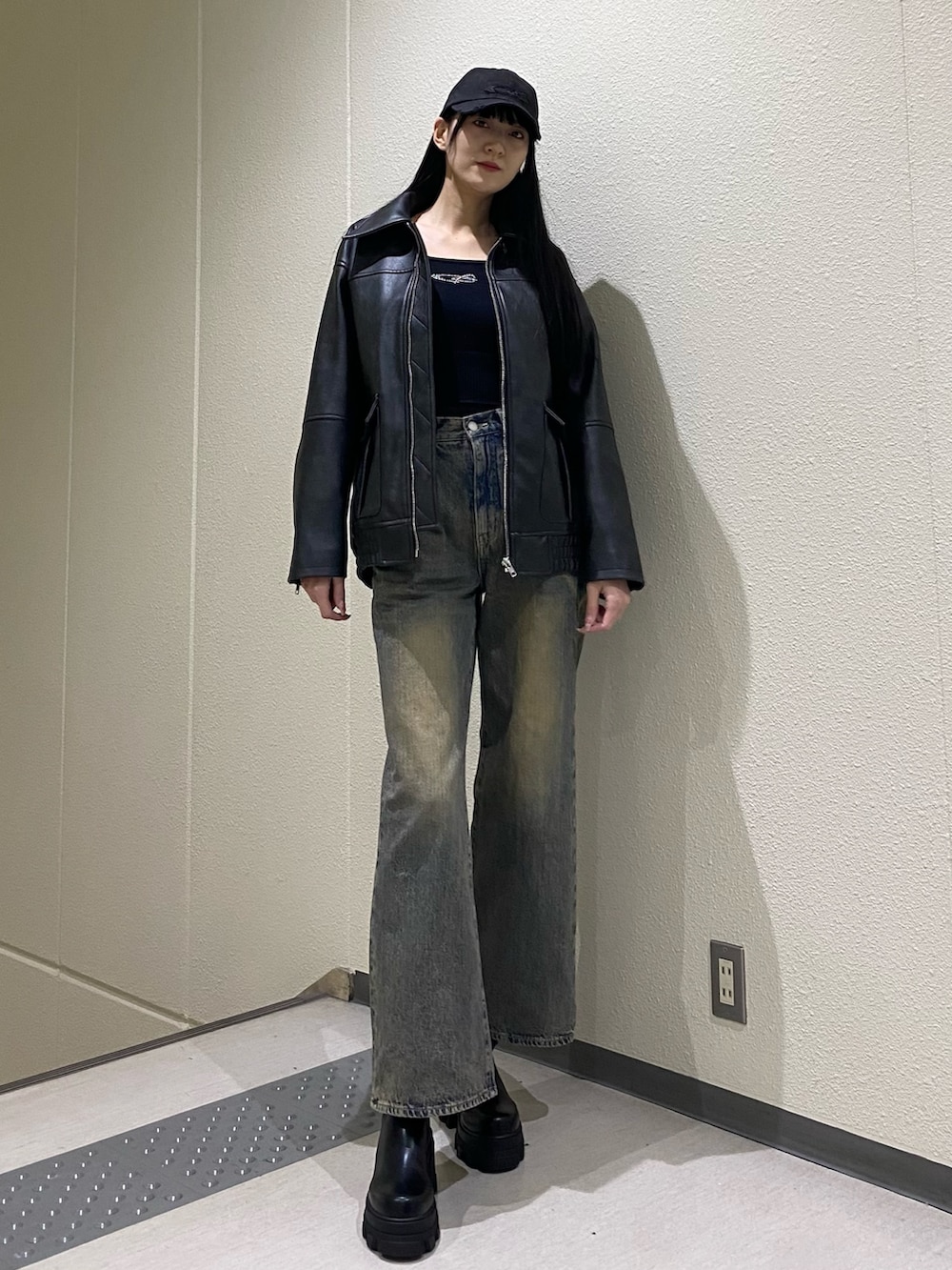 ブルー系のデニムパンツ、ブラック系のブルゾン、ブラック系のニット/セーターを着用したレディースの冬コーディネートの2枚目の写真