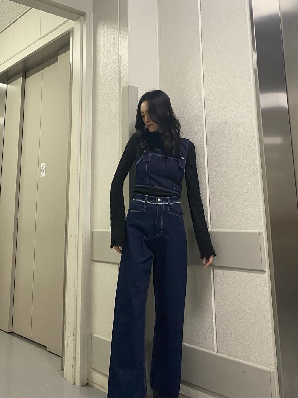 ブラック系のTシャツ/カットソー、ブルー系のデニムパンツ、ブルー系のベストを着用したレディースの春コーディネートの2枚目の写真