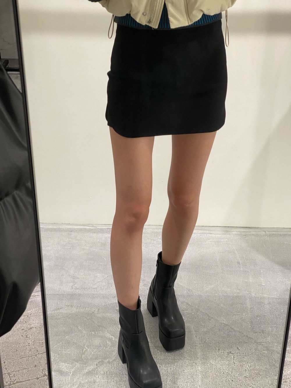 ブラック系のスカート、ブラック系のブーツ、ブルー系のニット/セーターを着用したレディースの秋コーディネートの6枚目の写真