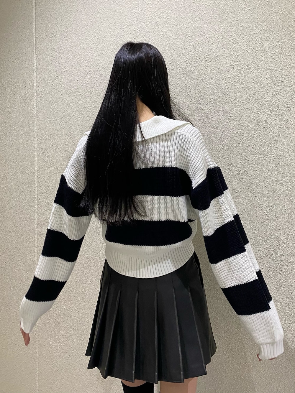 ブラック系のスカート、その他のニット/セーター、ブラック系のブーツを着用したレディースの冬コーディネートの8枚目の写真