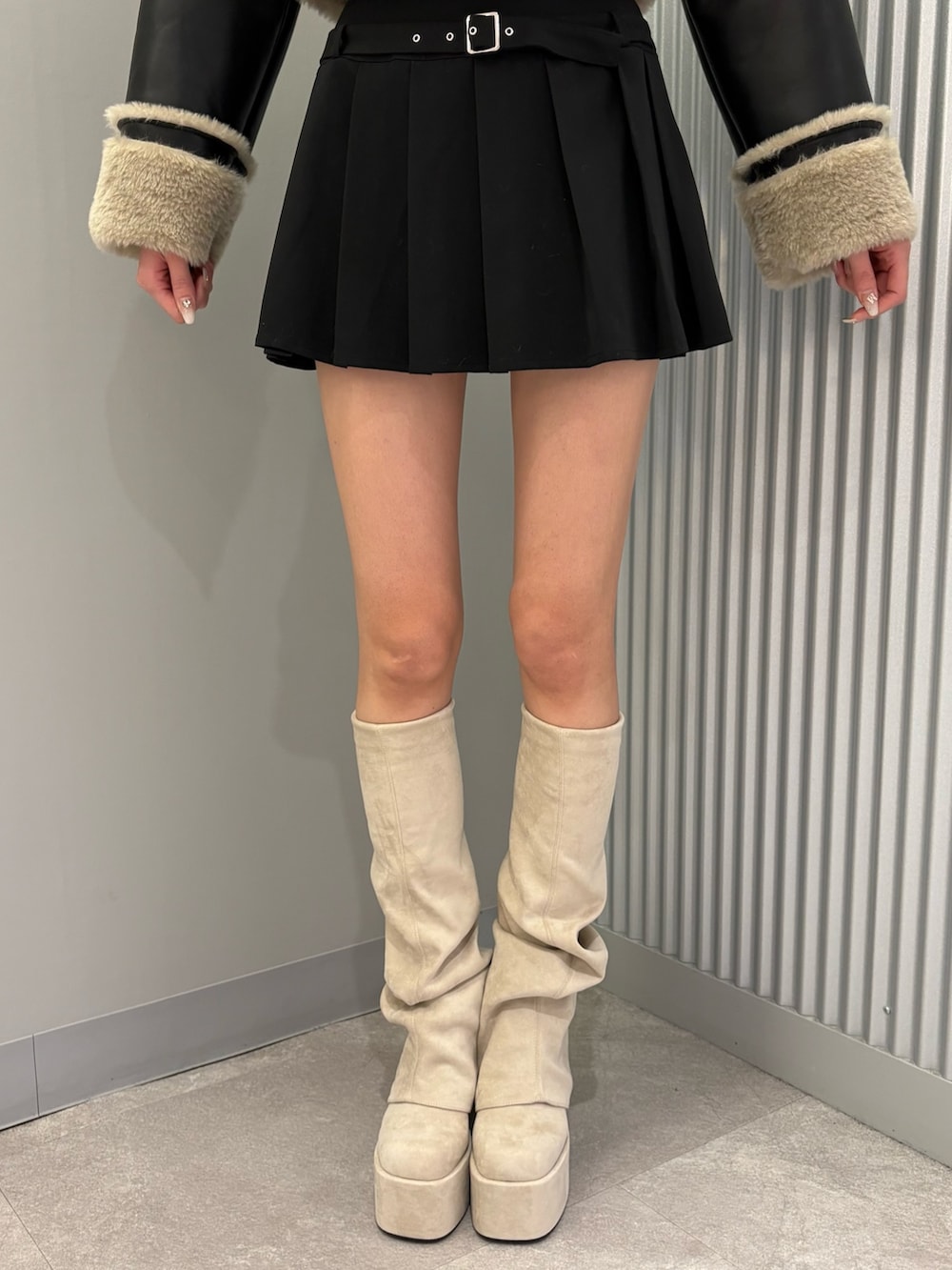 ブラック系のスカート、その他のブルゾン、ホワイト系のブーツを着用したレディースの秋コーディネートの9枚目の写真