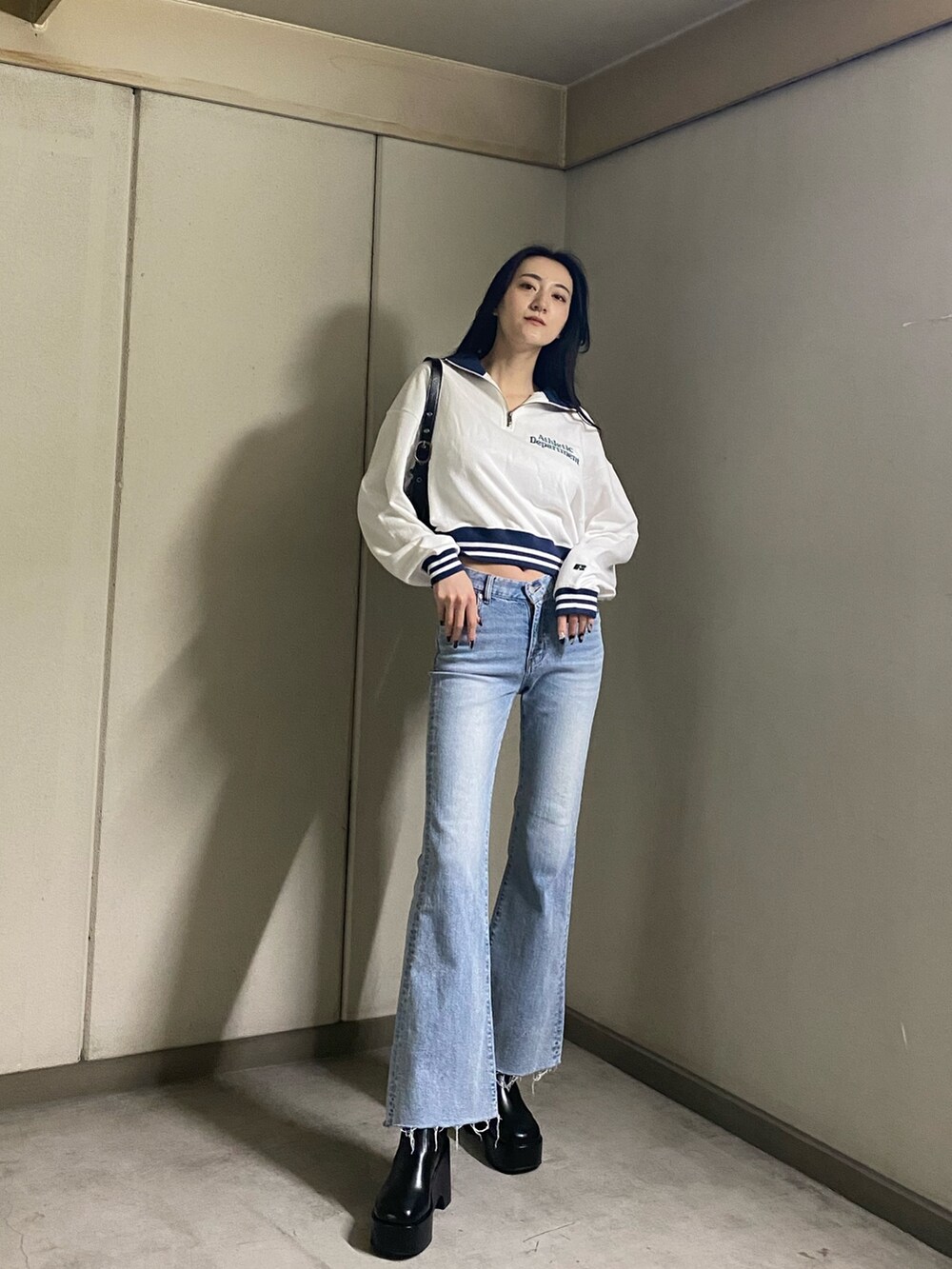 ホワイト系のTシャツ/カットソー、ブルー系のデニムパンツ、ブラック系のブーツを着用したレディースの春コーディネートの2枚目の写真