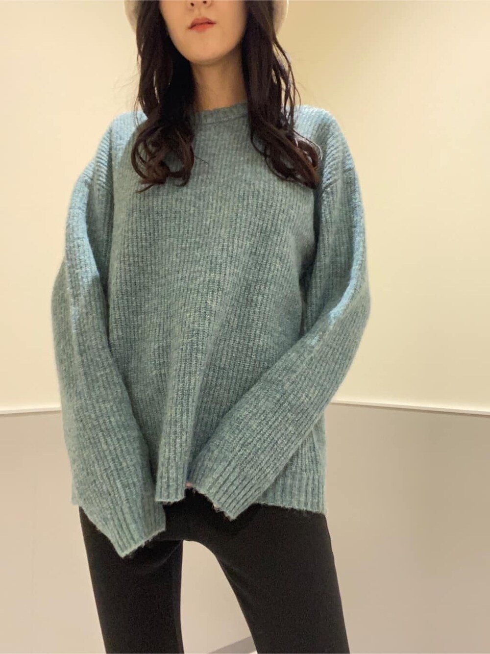 ブラック系のハンドバッグ、ブルー系のニット/セーター、ブラック系のその他パンツを着用したレディースの秋コーディネートの5枚目の写真