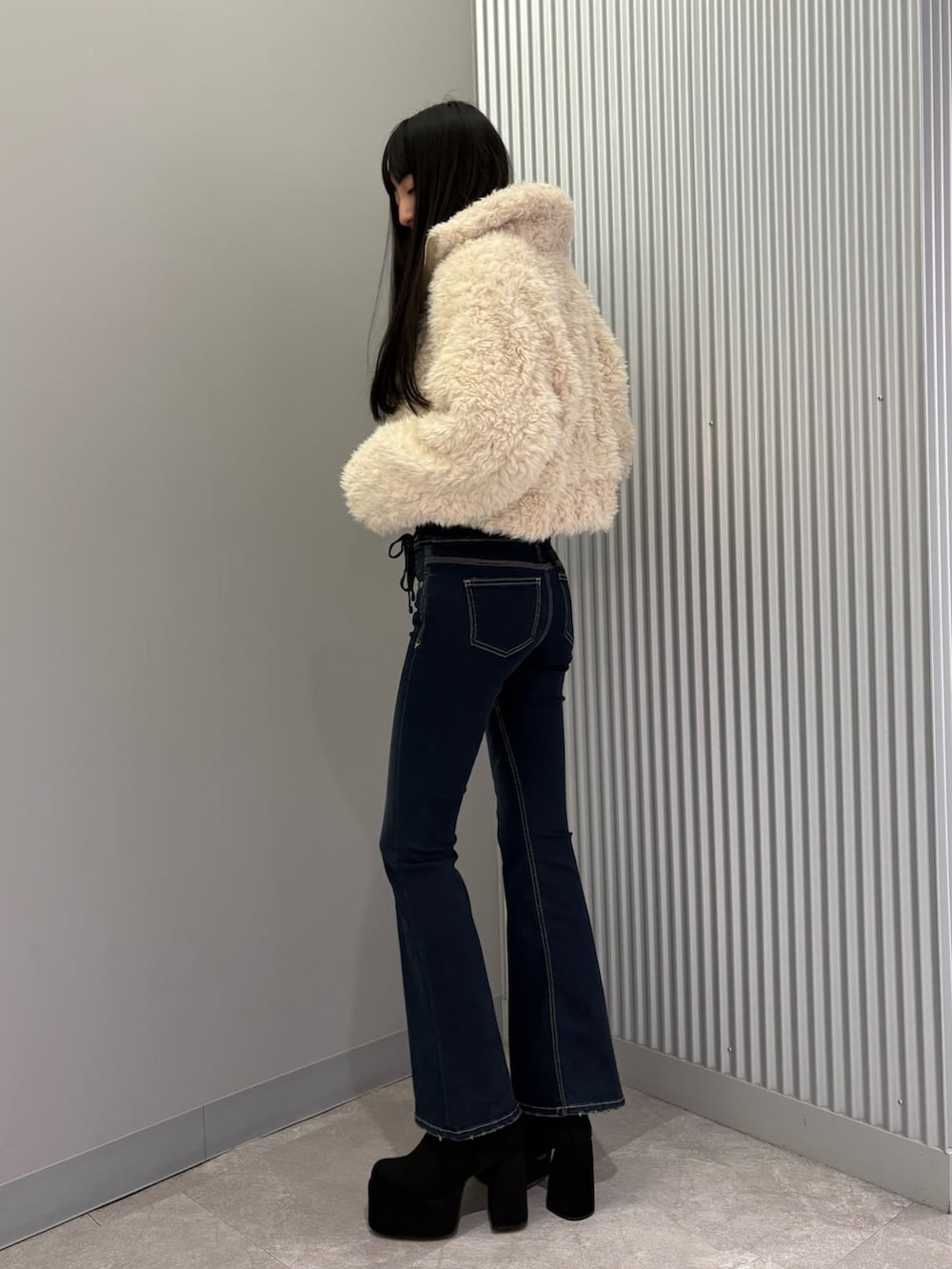 ブルー系のデニムパンツ、ホワイト系のブルゾン、グレー系のニット/セーターを着用したレディースの秋コーディネートの2枚目の写真