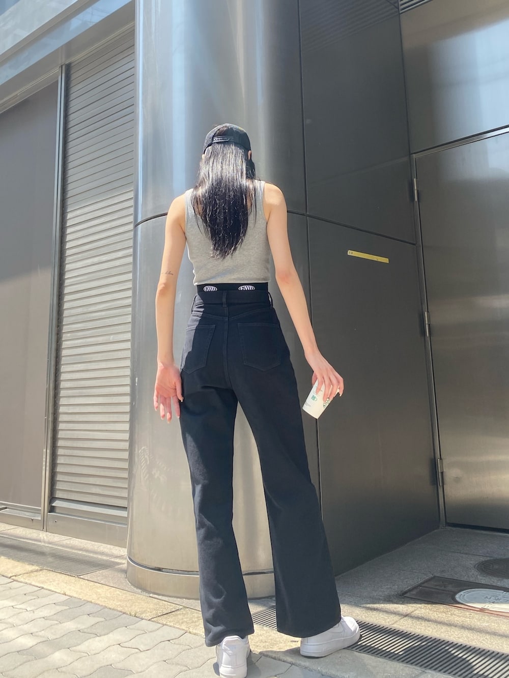 ブラック系のデニムパンツ、グレー系のTシャツ/カットソー、ブラック系のキャップを着用したレディースの夏コーディネートの4枚目の写真