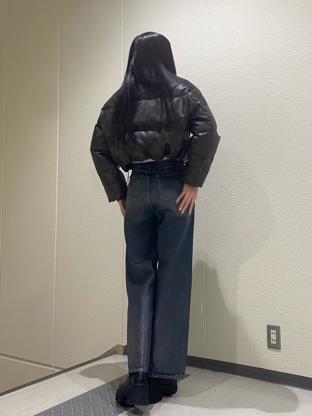 ブルー系のデニムパンツ、ブラウン系のダウンジャケット/コート、ブラック系のブーツを着用したレディースの冬コーディネートの3枚目の写真