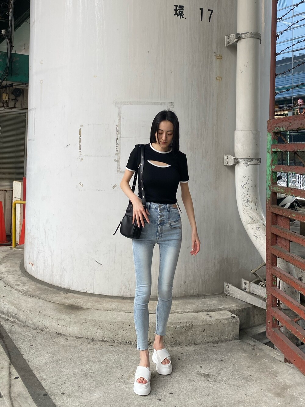 ブラック系のTシャツ/カットソー、ブルー系のデニムパンツ、ホワイト系のサンダルを着用したレディースの夏コーディネートの3枚目の写真