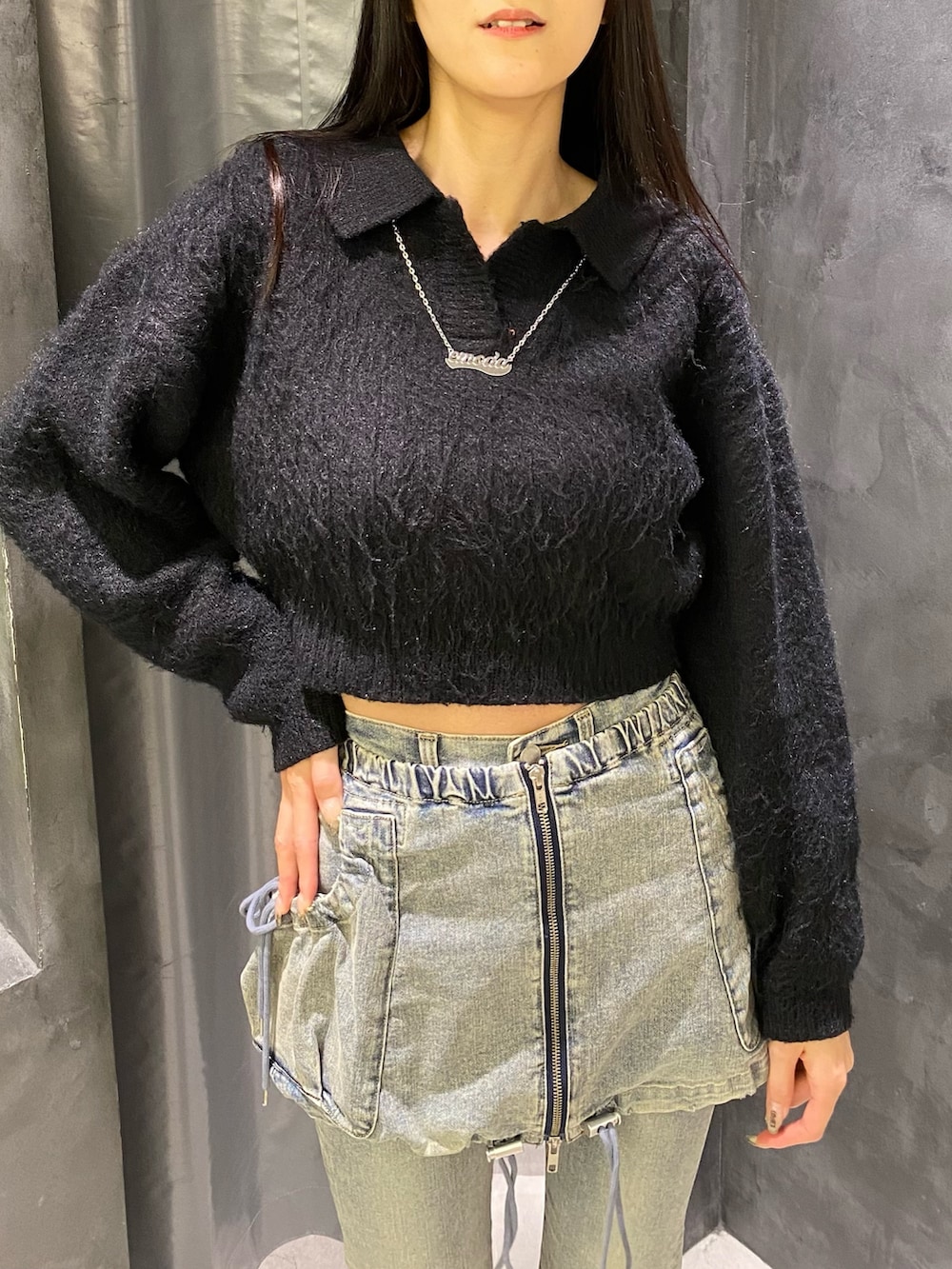 ブルー系のデニムパンツ、ブラック系のニット/セーター、ブラック系のブーツを着用したレディースの秋コーディネートの5枚目の写真