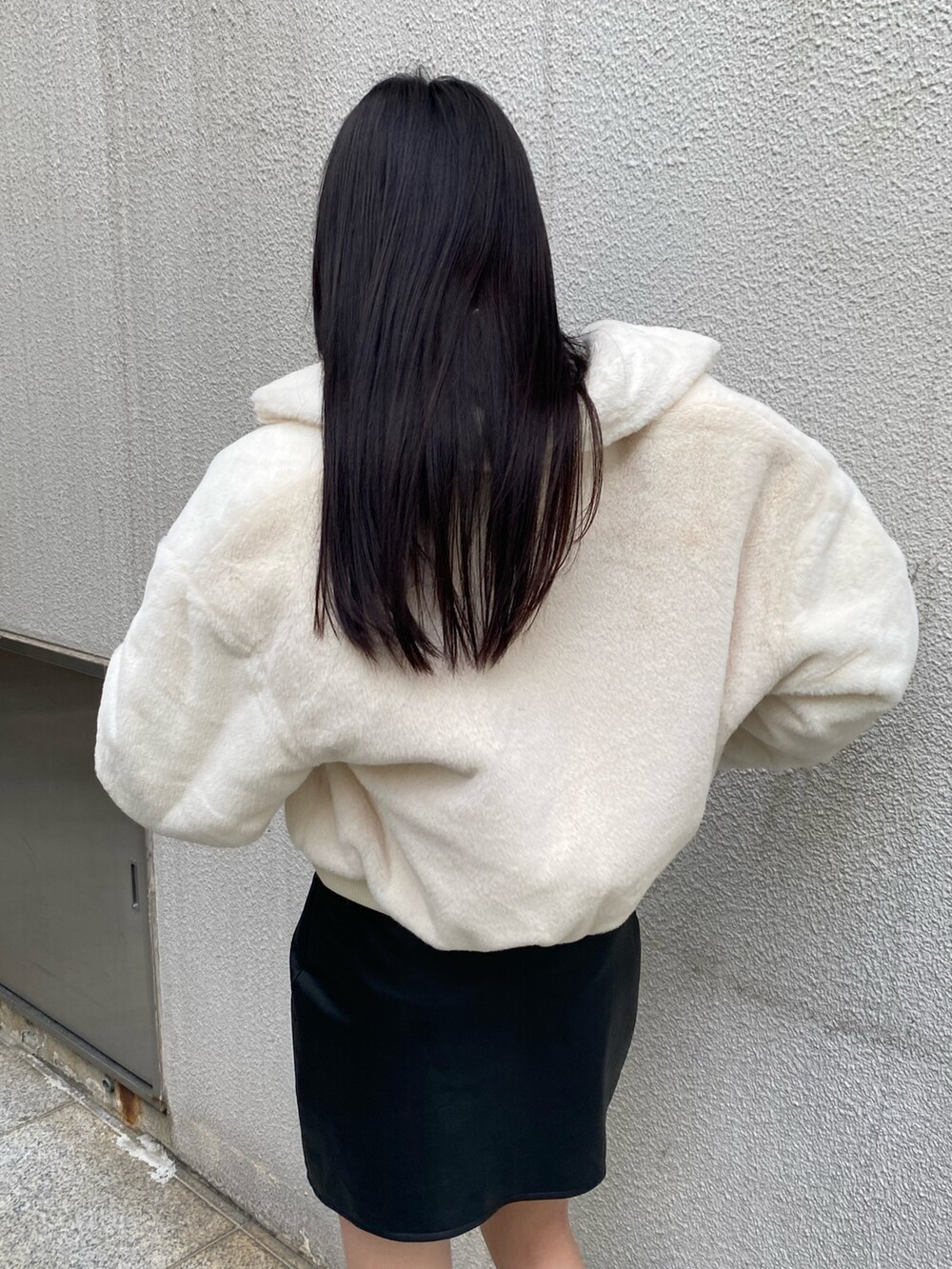 ブラック系のニット/セーター、ホワイト系のブルゾン、その他のスカートを着用したレディースの秋コーディネートの6枚目の写真