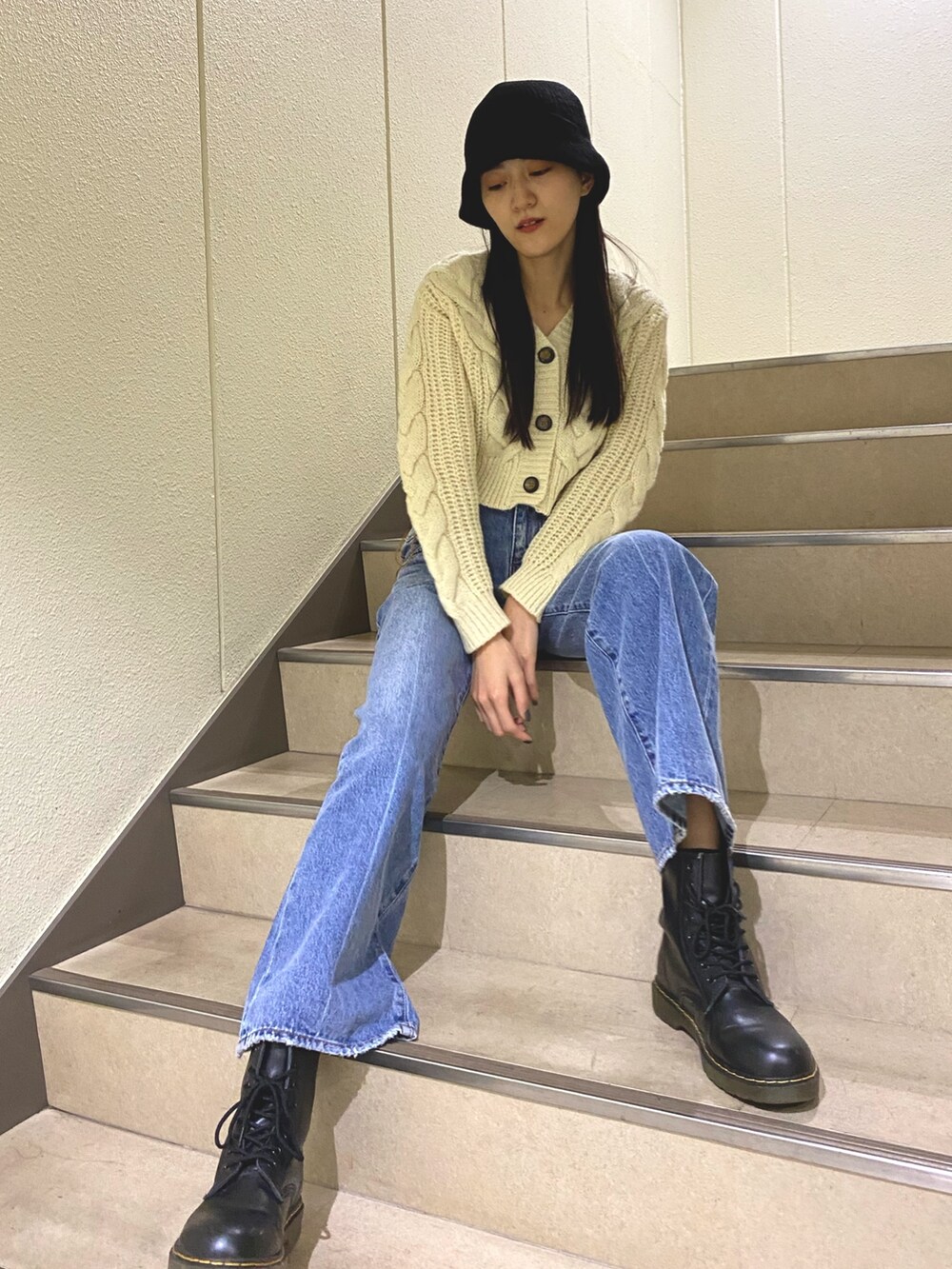 ブルー系のデニムパンツ、ホワイト系のカーディガン/ボレロ、ブラック系のハットを着用したレディースの秋コーディネートの2枚目の写真