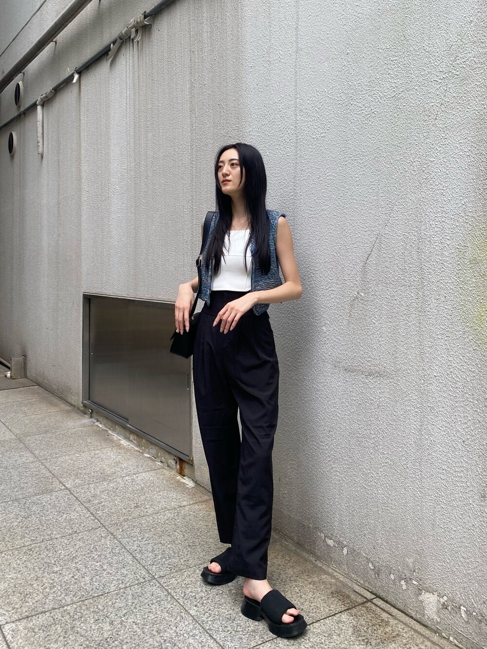 ホワイト系のニット/セーター、ブラック系のその他パンツ、ブラック系のショルダーバッグを着用したレディースの夏コーディネートの2枚目の写真