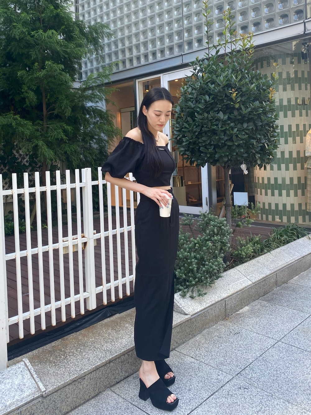 ブラック系のスカート、ブラック系のTシャツ/カットソー、シルバー系のネックレスを着用したレディースの夏コーディネートの2枚目の写真