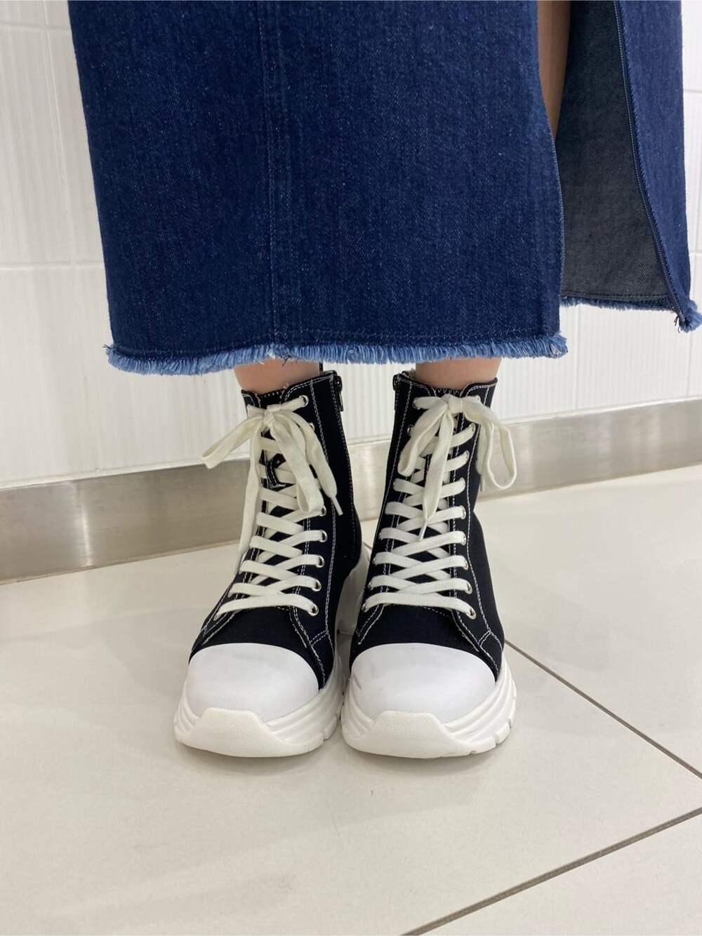 ブルー系のデニムジャケット、ブルー系のスカート、ホワイト系のハンドバッグを着用したレディースの夏コーディネートの10枚目の写真