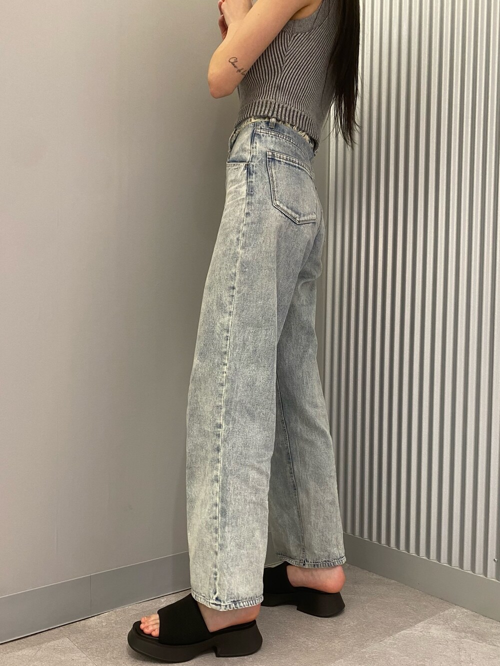 ブルー系のデニムパンツ、グレー系のニット/セーター、ブラック系のサンダルを着用したレディースの春コーディネートの7枚目の写真