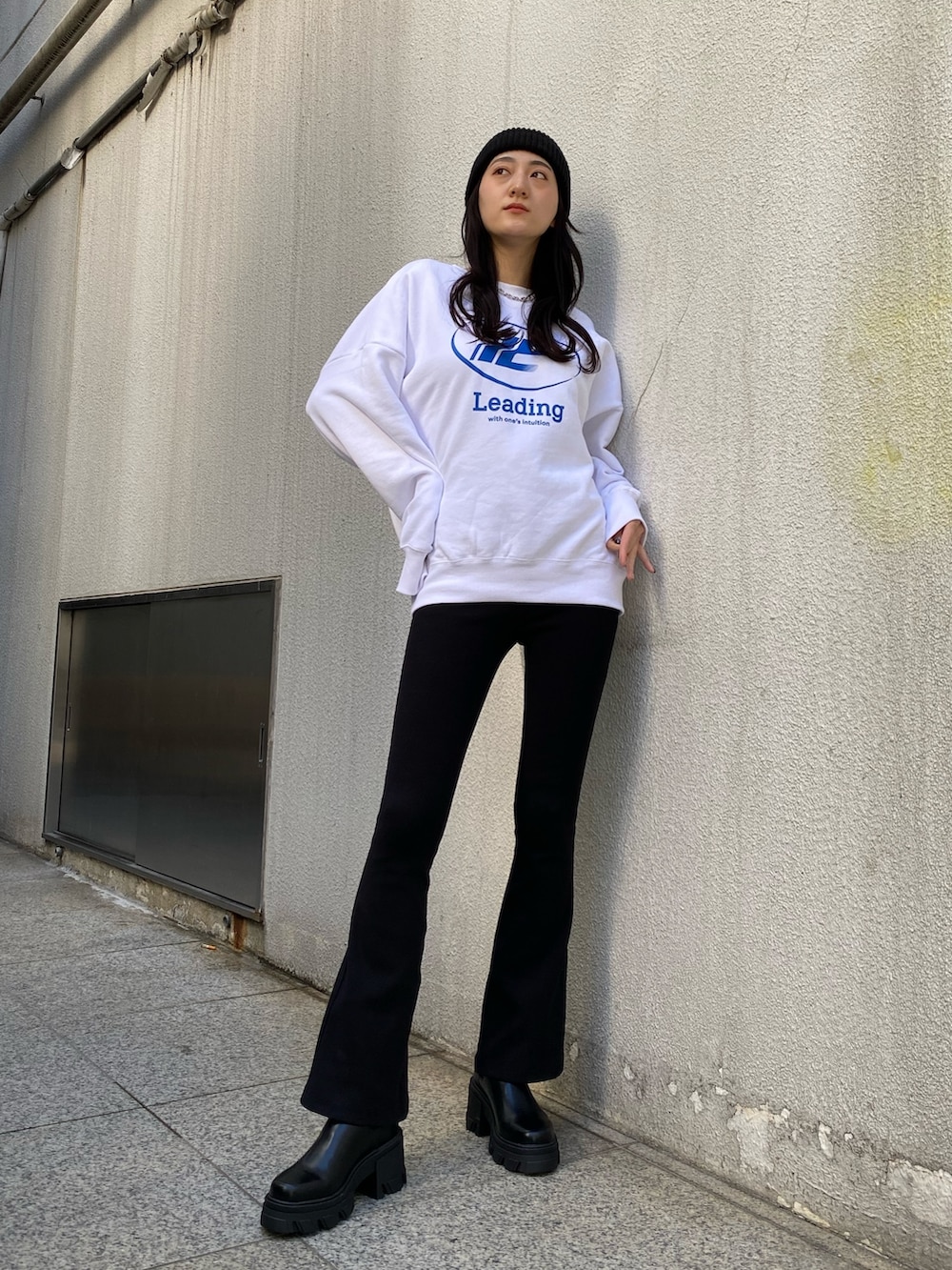 ホワイト系のスウェット、ブラック系のその他パンツ、ブラック系のブーツを着用したレディースの冬コーディネートの2枚目の写真