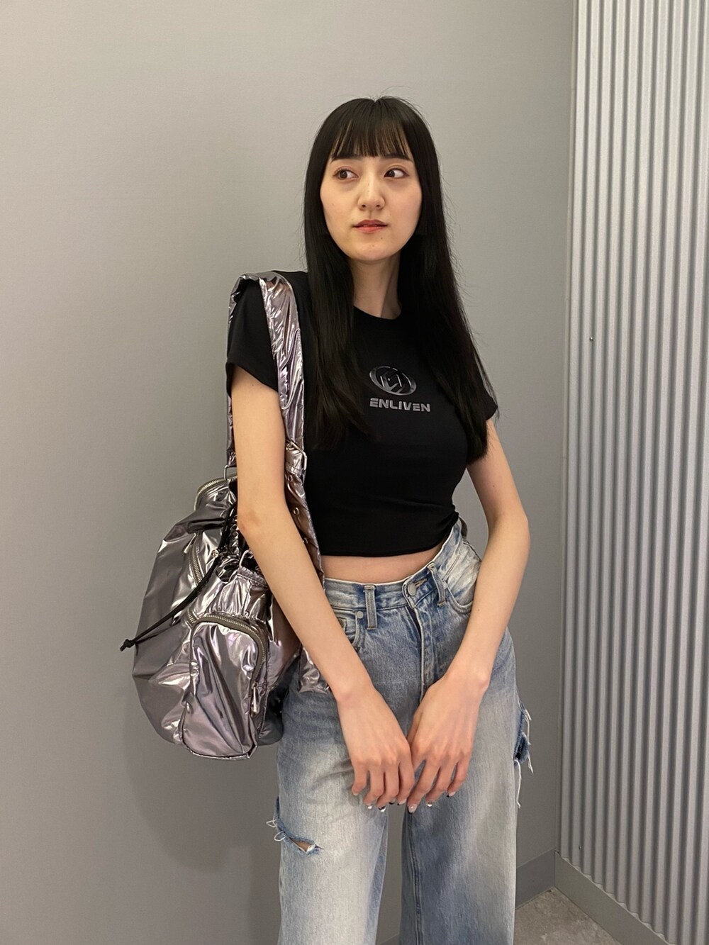 ブラック系のTシャツ/カットソー、ブラック系のサンダル、ブルー系のデニムパンツを着用したレディースの夏コーディネートの5枚目の写真