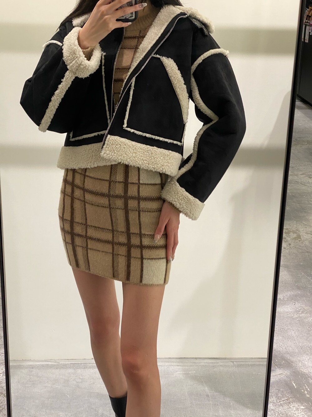 ベージュ系のスカート、ベージュ系のニット/セーター、ブラック系のブーツを着用したレディースの冬コーディネートの5枚目の写真