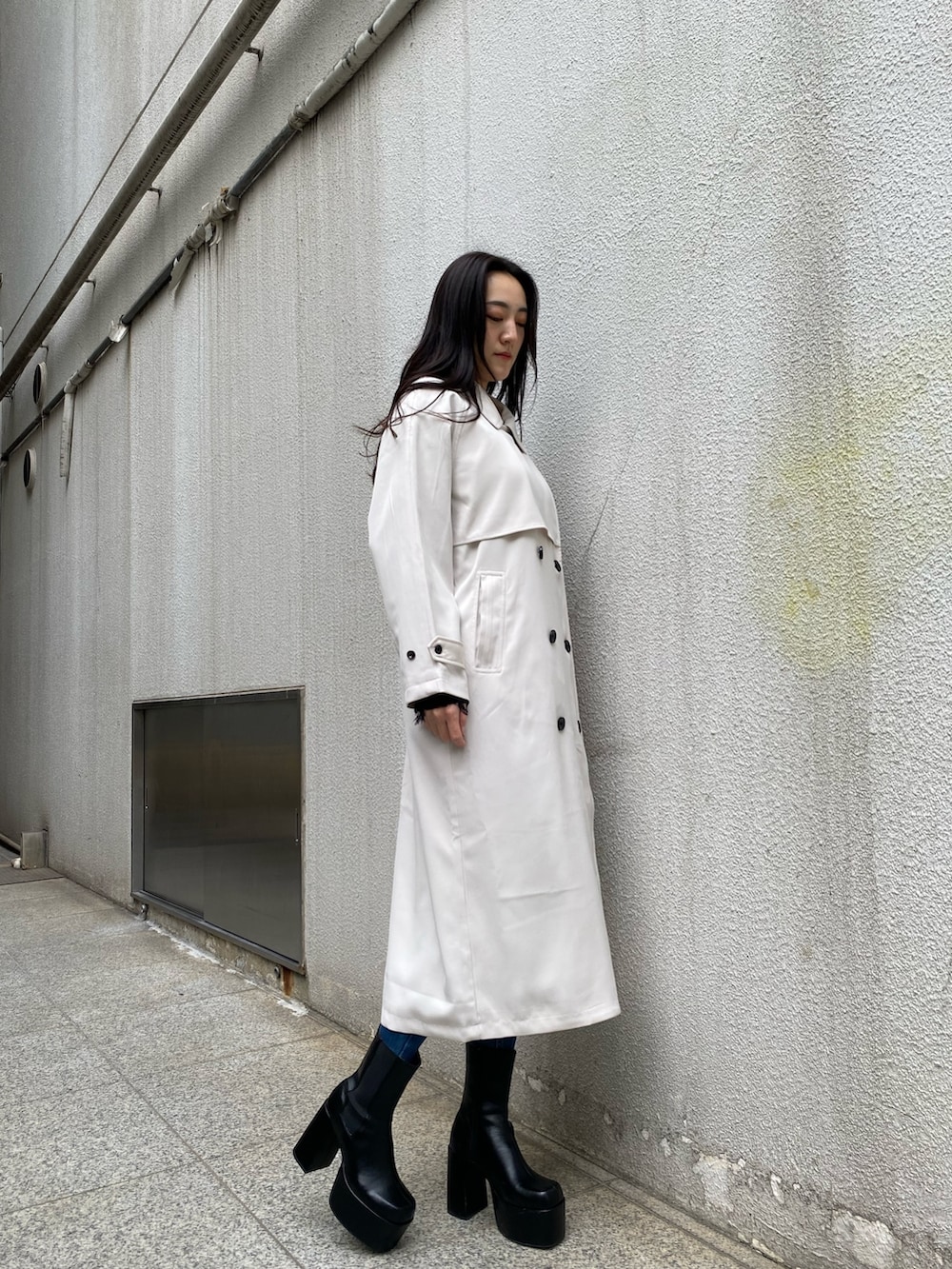 ブラック系のニット/セーター、ブルー系のデニムパンツ、ブラック系のブーツを着用したレディースの冬コーディネートの7枚目の写真