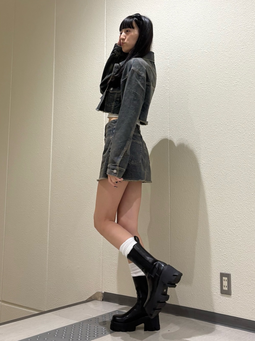 ブルー系のスカート、ブルー系のデニムジャケット、ホワイト系のキャミソールを着用したレディースの夏コーディネートの3枚目の写真