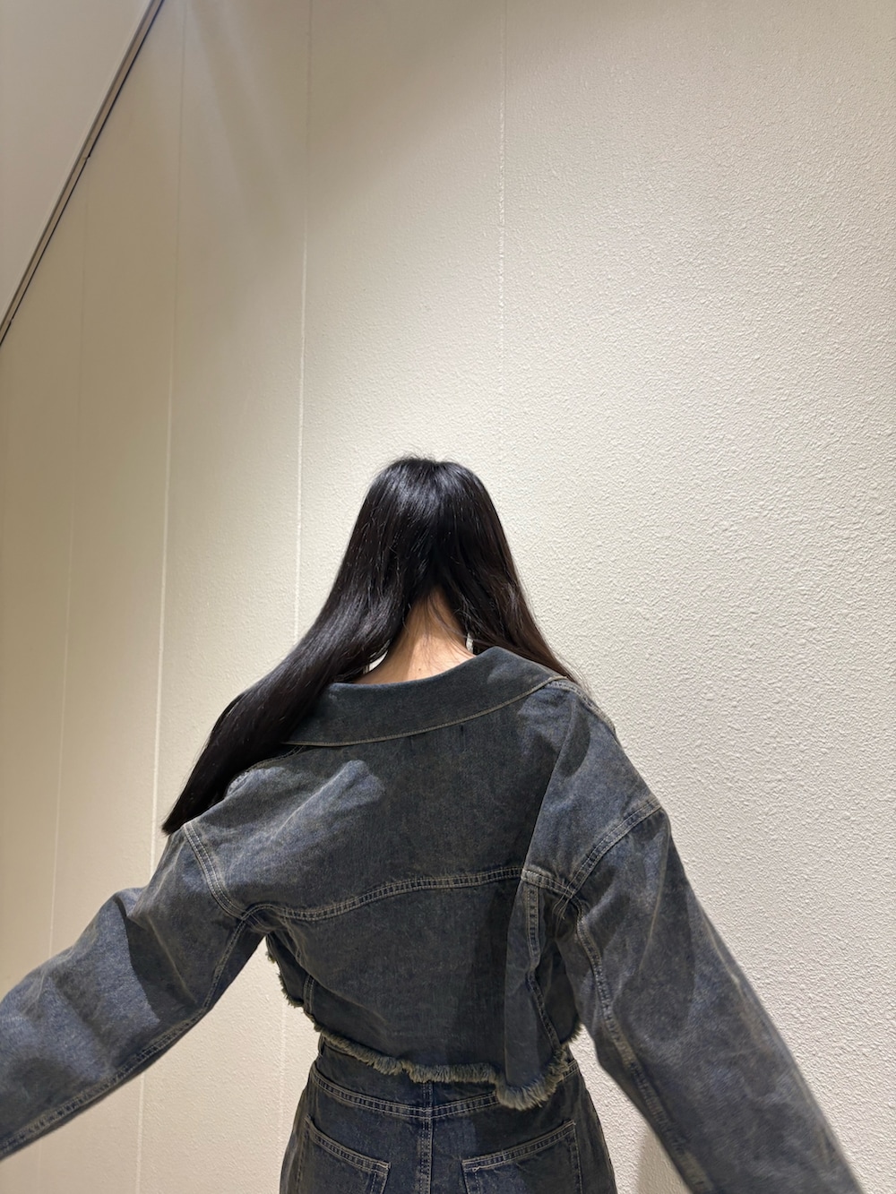 ブルー系のスカート、ブルー系のデニムジャケット、ホワイト系のキャミソールを着用したレディースの夏コーディネートの7枚目の写真